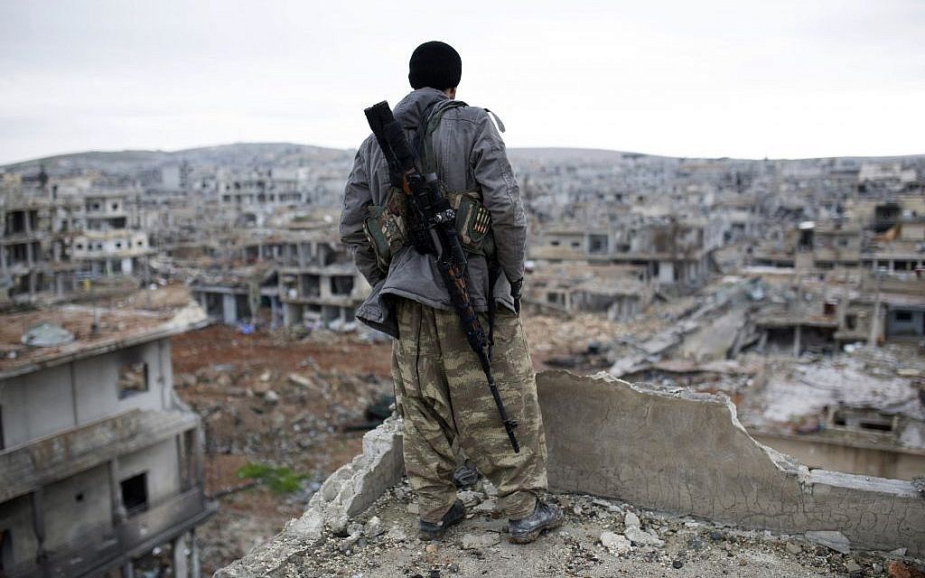 A Syrian Kurdish sniper looks at the rubble in the Syrian city of Ain al-Arab, also known as Kobani, Jan. 30, 2015. (AP, File)