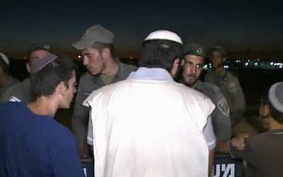 Protesters argue with Border Police forces charged with clearing them from the former West Bank settlement of Sa-Nur, where some 200 demonstrators were occupying the ruins of the settlement evacuated in 2005. Screenshot/Ynet)