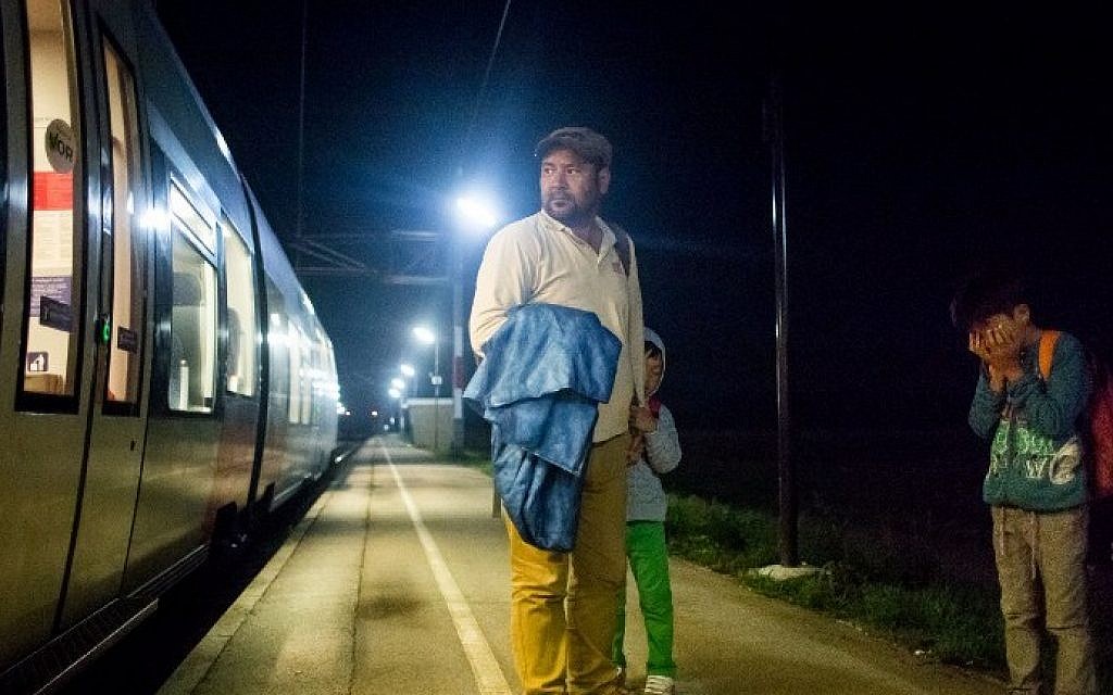 A man and his sons, migrants from Iran, wait for the train on their way to Vienna on August 31, 2015. Nickelsdorf is the first village in Austria on the way from Hungary.  (Vladimir Simicek/AFP)