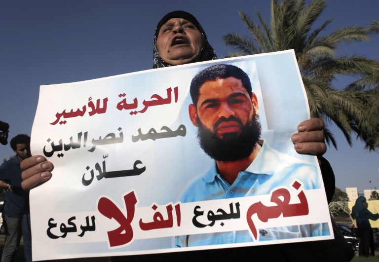 Maazouze, the mother of Mohammed Allaan, a Palestinian prisoner who is on a long-term hunger strike, holds a portrait of her son during a rally calling for his release in the southern Israeli city of Beersheba on August 9, 2015. (AFP/Ahmad Gharabli)