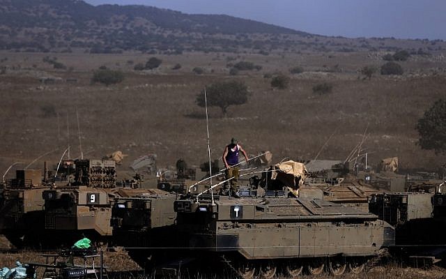 An Israeli soldier stands on top of an armored personnel carrier stationed on the Israeli side of the Golan Heights on August 21, 2015. (AFP Photo/Ahmad Gharabli)