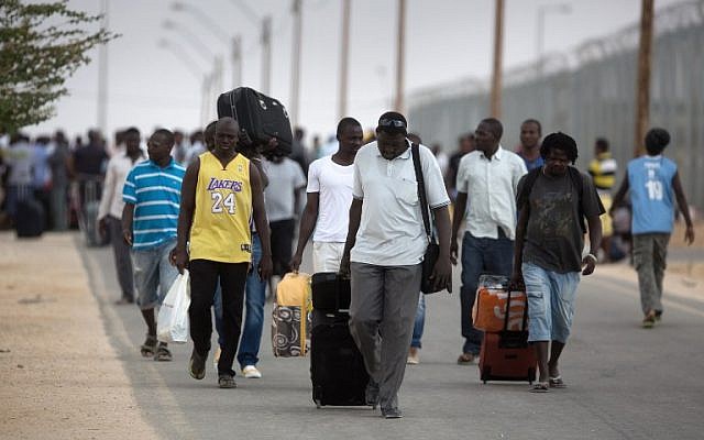 African migrants carry their belongings following their release from the Holot Detention Center in the Negev desert, on August 25, 2015. (AFP PHOTO/MENAHEM KAHANA)