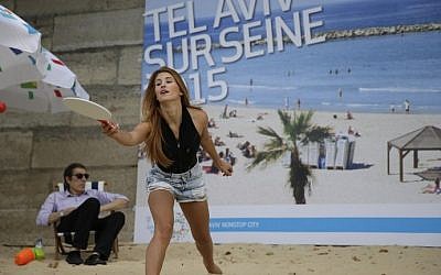 A woman plays beach tennis at the "Tel-Aviv sur Seine" beach attraction as part of the  14th edition of Paris Plages (Paris Beaches) in central Paris, on August 13, 2015. (Kenzo Tribouillard/AFP)