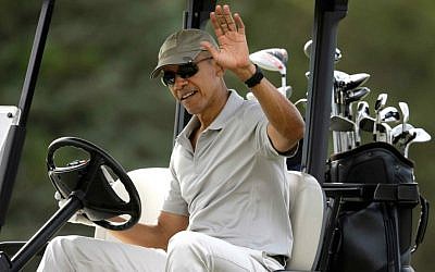 President Barack Obama waves to bystanders from his golf cart while golfing Saturday, Aug. 8, 2015, at Farm Neck Golf Club, in Oak Bluffs, Massachusetts, on the island of Martha's Vineyard. (AP Photo/Steven Senne)