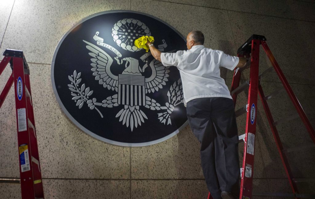 A worker wipes a representation of the The Great Seal of the United States at the newly opened US Embassy in Havana, Cuba, Friday, Aug. 14, 2015. (AP Photo/Ramon Espinosa)