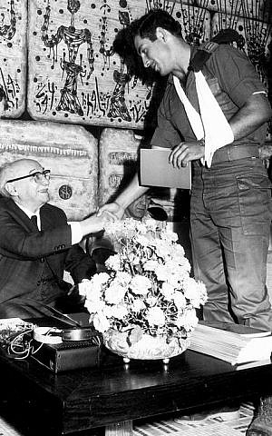 In this Israeli Government Press Office (GPO) file photo, then-Lieutenant Benjamin Netanyahu shakes hands with Israeli President Zalman Shazar during a ceremony honoring the soldiers from the elite Sayeret Matkal commando unit who freed the hostages in the Sabena Airlines hijacking, at the President's residence on November 1, 1972 (GPO/Flash90)