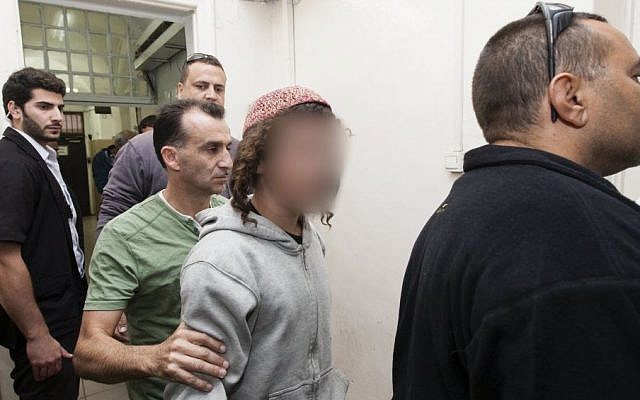 File: Alleged young Jewish extremist seen escorted by police in the Jerusalem Magistrate's Court where he was brought on suspicion of burning a house in Sinjil, a village in the West Bank, November 2013. (Flash90)