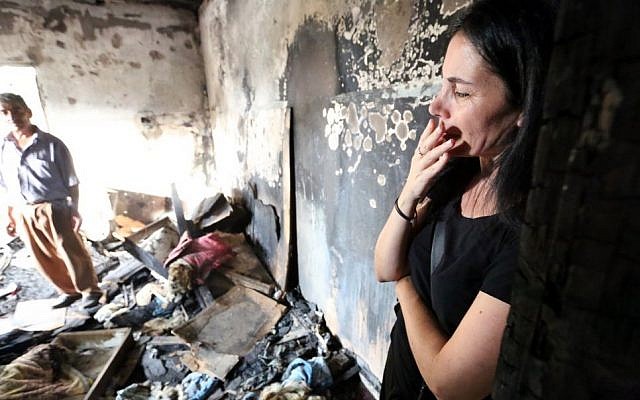An Israeli woman enters the burnt home of the Dawabsha family in Duma, August 2, 2015, following a terror attack the week before. (Yossi Zamir/Flash90)