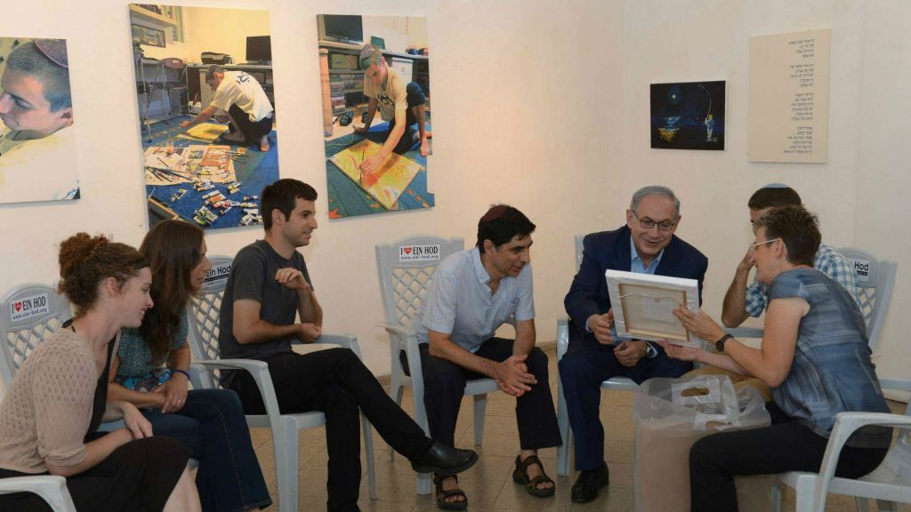 Prime Minister Benjamin Netanyahu visits an exhibition of paintings by the late Hadar Goldin, killed in battle in Gaza with his body never recovered, at the artists' village Ein Hod in northern Israel, on August 10, 2015. (Amos Ben Gershom/GPO)