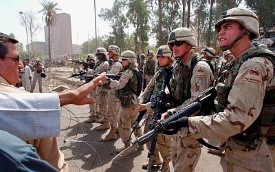 US soldiers prevent former Iraqi soldiers from trying to enter the American headquarters during a deadly demonstration in Baghdad, Iraq, on June 18, 2003. (AP Photo/Victor R. Caivano, File)