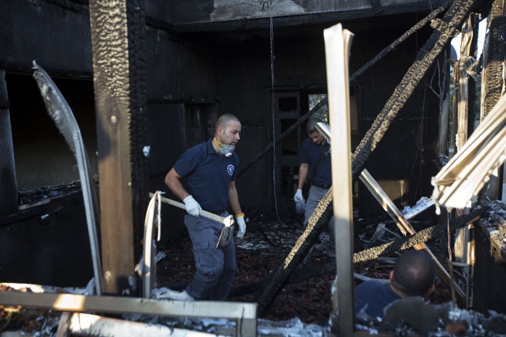 Israeli policemen inspect a house after it was torched in a suspected attack by Jewish terrorists killing an 18-month-old Palestinian child, at Duma village near the West Bank city of Nablus, Friday, July 31, 2015. (AP Photo/Majdi Mohammed)