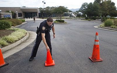 A Roanoke police officer moves road cones back into position after letting a vehicle through at WDBJ's Digital Broadcast Center, Wednesday, Aug. 26, 2015, in Roanoke, Va. (Erica Yoon/The Roanoke Times via AP)