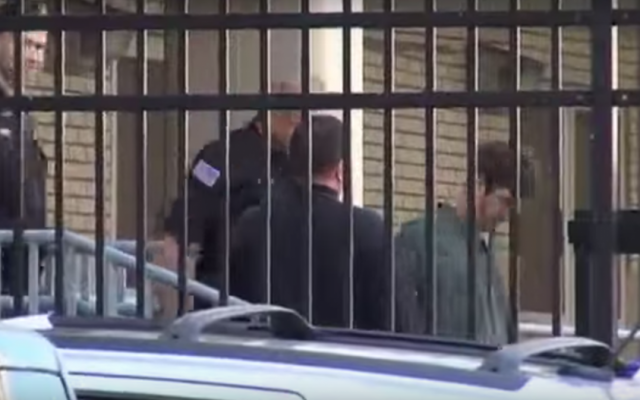 Glendon Scott Crawford accompanied by police after his arrest in 2013 (screen capture: YouTube)