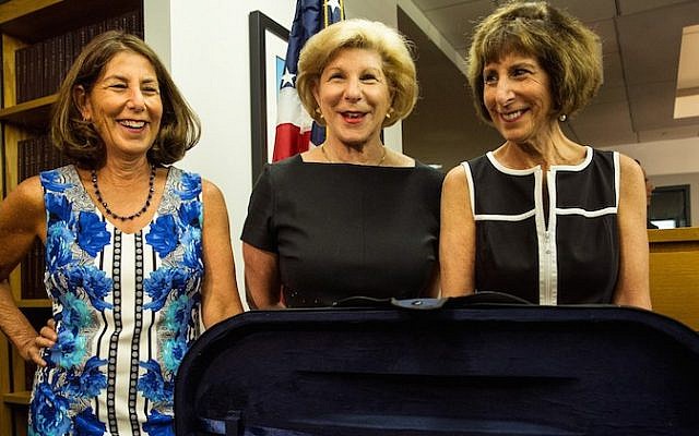 (Left to right) Amy Totenberg, Nina Totenberg and Jill Totenberg view their father's Stadivarius violin, which was stolen after a concert 35 years ago, at an FBI press conference in New York City announcing the recovery of the violin, on August 6, 2015. (Andrew Burton/Getty Images/JTA)
