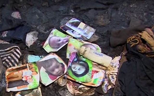 Family photos lie in the remains of the Dawabsha home in the West Bank village of Duma, after it was firebombed by suspected Jewish extremists on July 31, 2015. The family's 18-month-old baby was killed in the attack and his father died of his injuries eight days later, on August 8, 2015. (screen capture: YouTube)
