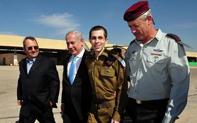 Released Israeli soldier Gilad Shalit (second right), walks with Prime Minister Benjamin Netanyahu (second left), then-defense minister Ehud Barak (left), and ex-chief of staff Lt. Gen. Benny Gantz (right), at the Tel Nof air base in southern Israel, October 18, 2011. (Ariel Hermoni/Defense Ministry/Flash90)