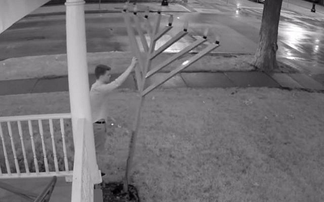 An image from security-camera footage released by the University of Illinois police, showing a man knocking over the campus menorah, August 21, 2015. (screen capture: YouTube)