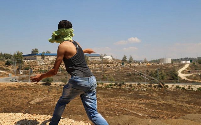 Illustrative: A Palestinian from the West Bank village of Nabi Saleh slings a rock at IDF soldiers (Eric Cortellessa/Times of Israel)