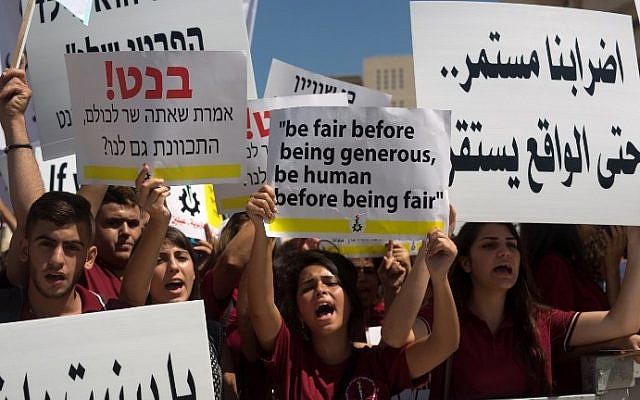 Arab Israeli Christian students hold placards during a protest in Jerusalem to demand more funds for Christian schools, on September 6, 2015. (AFP/Menahem Kahana)