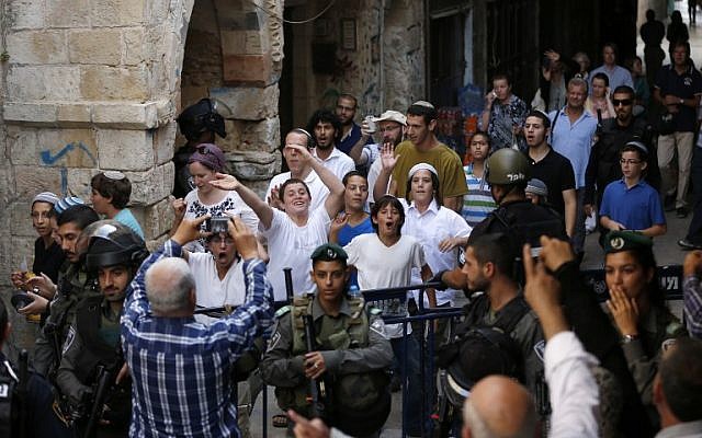 Security forces stand guard as a group of Jewish youth leave after visiting al-Aqsa mosque compound in Jerusalem's Old City on September 13, 2015.  (AFP/AHMAD GHARABLI)
