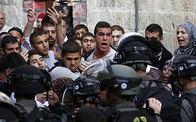 Palestinians shout in front of Israeli security forces who block a road leading to the Al-Aqsa mosque compound in Jerusalem's Old City on September 13, 2015. (AFP PHOTO / AHMAD GHARABLI)