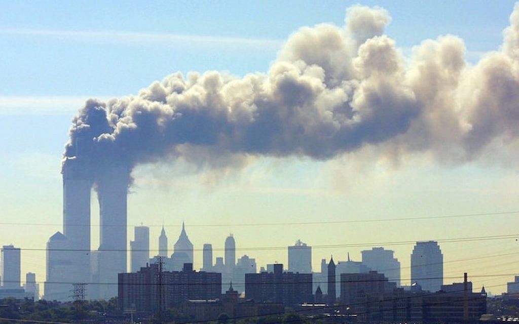 As seen from the New Jersey Turnpike, smoke billows from the Twin Towers of the World Trade Center in New York City after airplanes crashed into both towers, September 11, 2001. (JTA/AP/Gene Boyars)