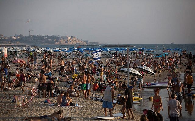 Illustrative: Thousands of Israelis and tourists seen on the beach in Tel Aviv on a hot summer day. July 25, 2015. (Miriam Alster/FLASH90)