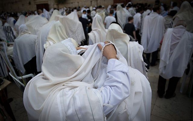 Jewish worshipers cover themselves with prayer shawls as they pray in front of the Western Wall,  in Jerusalem's Old City, during Passover, April 6, 2015. Yonatan Sindel/Flash90)