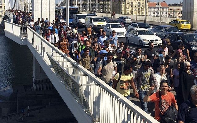 A large group of asylum seekers walk out of Budapest, Hungary, Sept. 4, 2015. (AP/Frank Augstein)