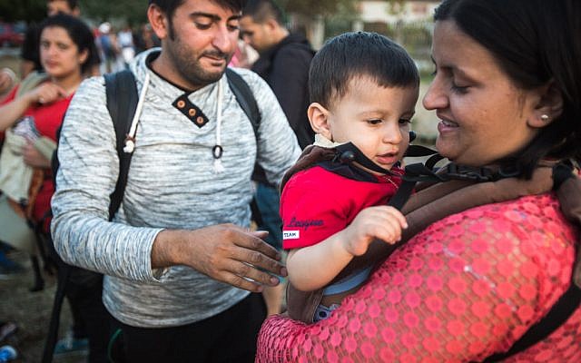 IsraAID volunteers deliver baby slings to Syrian and Afghan refugees on the Hungarian-Serbian border, September 15, 2015. (Photo: IsraAID)