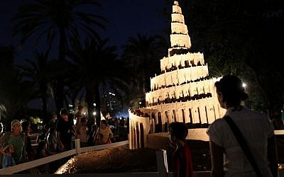 Museum visitors look at a sculpture made of sand of the 'Tower of Babel,' during the exhibit 'Tales in the Sand' at the Eretz Israel Museum several years ago (Nati Shohat/Flash 90)