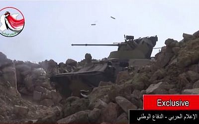 An armored personnel carrier, likely a Russian made BTR-82A, firing large-caliber bullets during a battle in Latakia, Syria, is seen in a video posted online on August 23, 2015. (Screen capture YouTube)