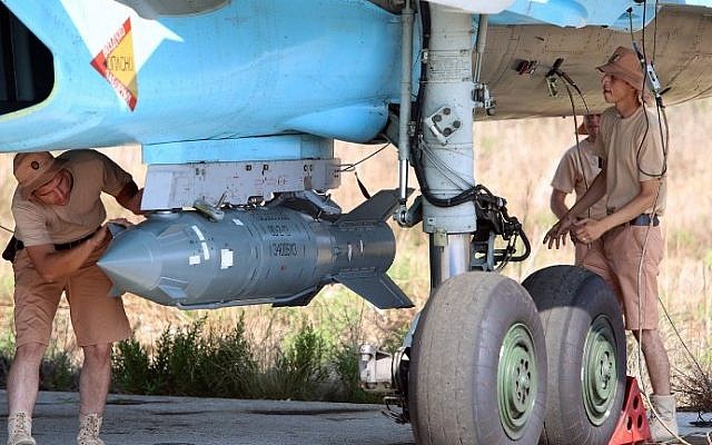 A picture taken on October 3, 2015, shows Russian air force technicians checking a Russian Su-34 fighter bomber at the Hmeimim airbase in the Syrian province of Latakia. (AFP/Komsomolskaya Pravda/Alexander Kots)
