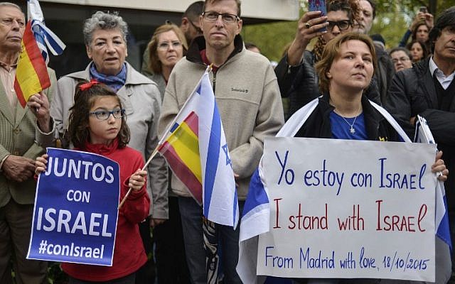 Supporters hold signs reading 'Together with Israel' at a rally called by the Federation of Jewish Communities in Spain (FCJE) and the Jewish Community of Madrid, in front of the Israeli embassy in Madrid on October 18, 2015. (AFP PHOTO/PEDRO ARMESTRE)