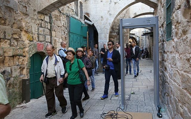 Tourists walk past a metal detector in the Muslim quarter of Jerusalem's Old City on October 8, 2015 following a spate of knife attacks. (AFP Photo/Gali Tibon)