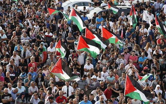 Arab Israelis, some holding Palestinian flags, take part in a large demonstration as part of a general strike organized to support the Palestinians on October 13, 2015 in the northern Arab-Israeli town of Sakhnin (AFP PHOTO/JACK GUEZ)