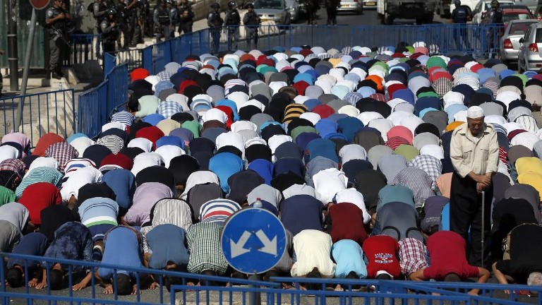 Israeli security forces stand guard as Palestinian Muslim worshipers take part in Friday noon prayers in the Ras al-Amud neighborhood in East Jerusalem, on October 16, 2015, following Israeli restrictions on the Temple Mount. (AFP/ AHMAD GHARABLI)
