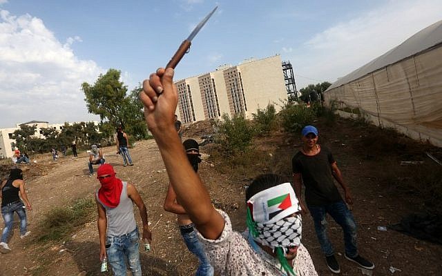 A Palestinian youth raises a knife during clashes with Israeli security forces (unseen) in the West Bank city of Tulkarem on October 18, 2015. (AFP/JAAFAR ASHTIYEH)