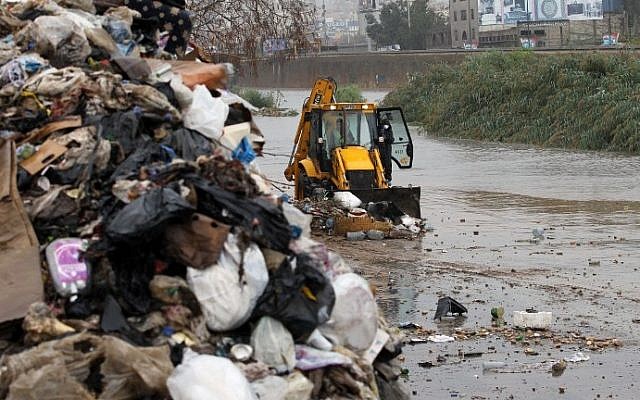 A bulldozer cleans the Beirut river from garbage as part of a campaign during heavy rain on October 25, 2015. There are fears the uncollected waste, coupled with the looming rainy season, could spread diseases such as cholera among the population. (AFP PHOTO / ANWAR AMRO)