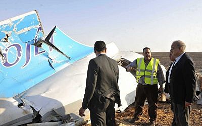 In this image released by the Prime Minister's office, Sherif Ismail, right, looks at the remains of a crashed passenger jet in Hassana Egypt, Friday, Oct. 31, 2015. A Russian aircraft carrying 224 people, including 17 children, crashed Saturday in a remote mountainous region in the Sinai Peninsula about 20 minutes after taking off from a Red Sea resort popular with Russian tourists, the Egyptian government said. There were no survivors. (Suliman el-Oteify, Egypt Prime Minister's Office via AP)