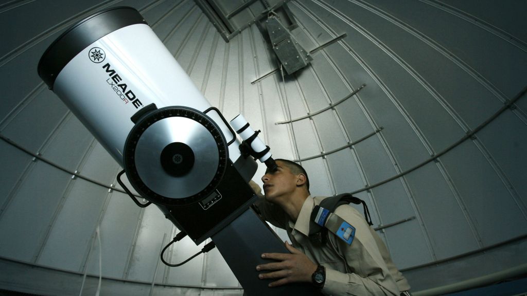 An illustrative photo of a student from an IDF air force school watching the stars through a telescope at a planetarium in Ma'ale Adumim, January 13, 2008. (Michal Fattal /FLASH90)