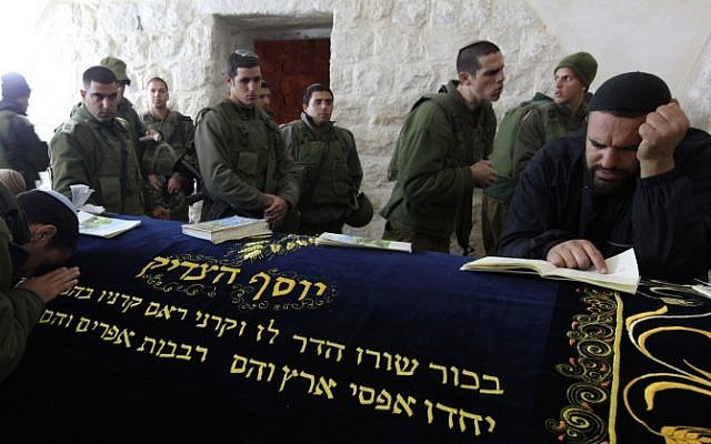 Aman prays as he is surrounded by Israeli soldiers in Joseph's Tomb in the West Bank city of Nablus, December 28, 2010. (Kobi Gideon/Flash90)