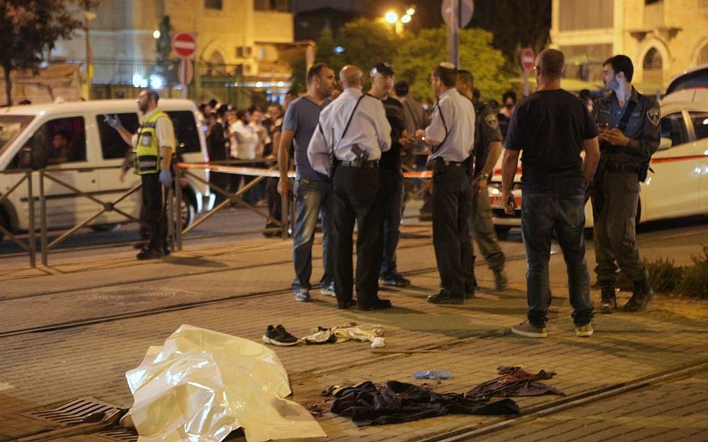 Israeli police standing near the body of Fadi Yaloon, a Palestinian who allegedly stabbed a 15-year-old, outside Jerusalem’s Old City early Sunday morning, October 4, 2015. (Flash90)
