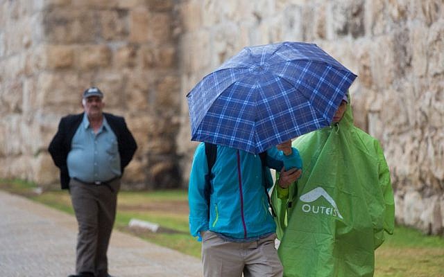 People hold umbrellas to protect themselves from the rain as they walk by Jaffa gate near the Tower of David in Jerusalem Old City during the first rain of the upcoming winter, October 7, 2015. (Photo by Yonatan Sindel / Flash90)