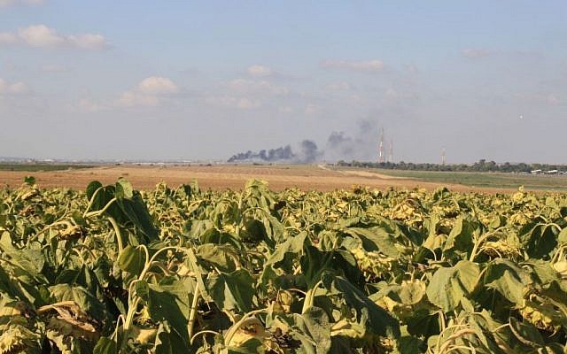 Illustrative: The fields of Kibbutz Nahal Oz, on the border of the Gaza Strip, where smoke rises in the distance. (Amir Tibon)