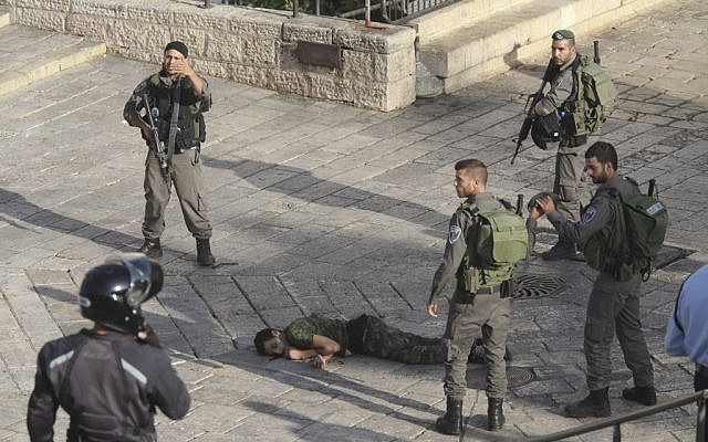 Israeli police stand around a Palestinian shot after he tried to stab a person at Damascus Gate of the Jerusalem's Old City, Wednesday, October 14, 2015. (AP/Oren Ziv)