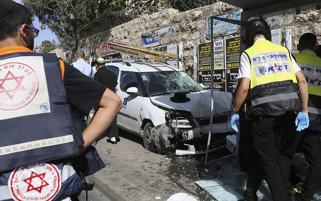 Police and emergency services respond to an attack in Jerusalem on October 13, 2015 after Palestinian rammed a vehicle into a bus stop then got out and started stabbing people. (AP/Oren Ziv)