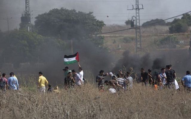 Palestinians gather during clashes with Israeli soldiers on the border near Gaza City, Friday, Oct. 9, 2015. (AP/Khalil Hamra)