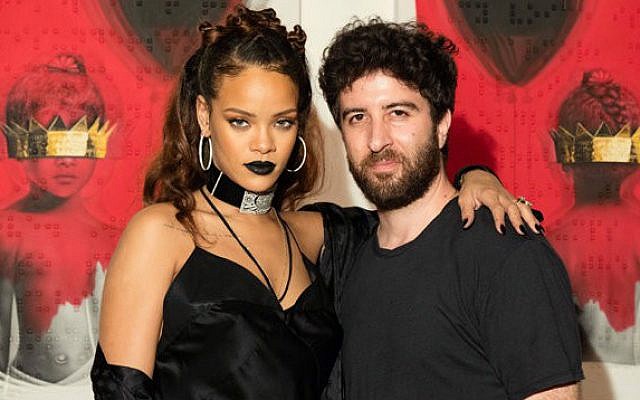Pop star Rihanna and her Israeli-born muse, Roy Nachum pose in front of the art he created for her latest album (Courtesy Roy Nachum)