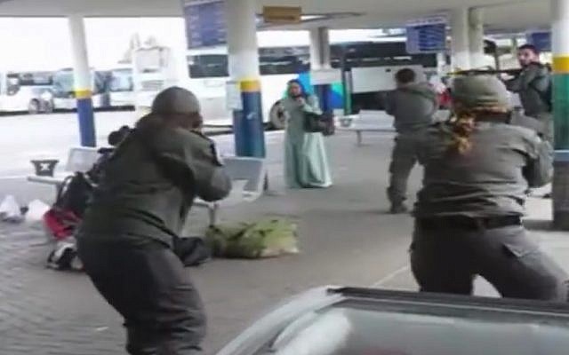 A still image taken from cellphone footage of security forces surrounding a knife-wielding Israeli Arab woman after she allegedly tried to stab a security guard at Afula bus station on Friday, October 9, 2015.  (screen capture)